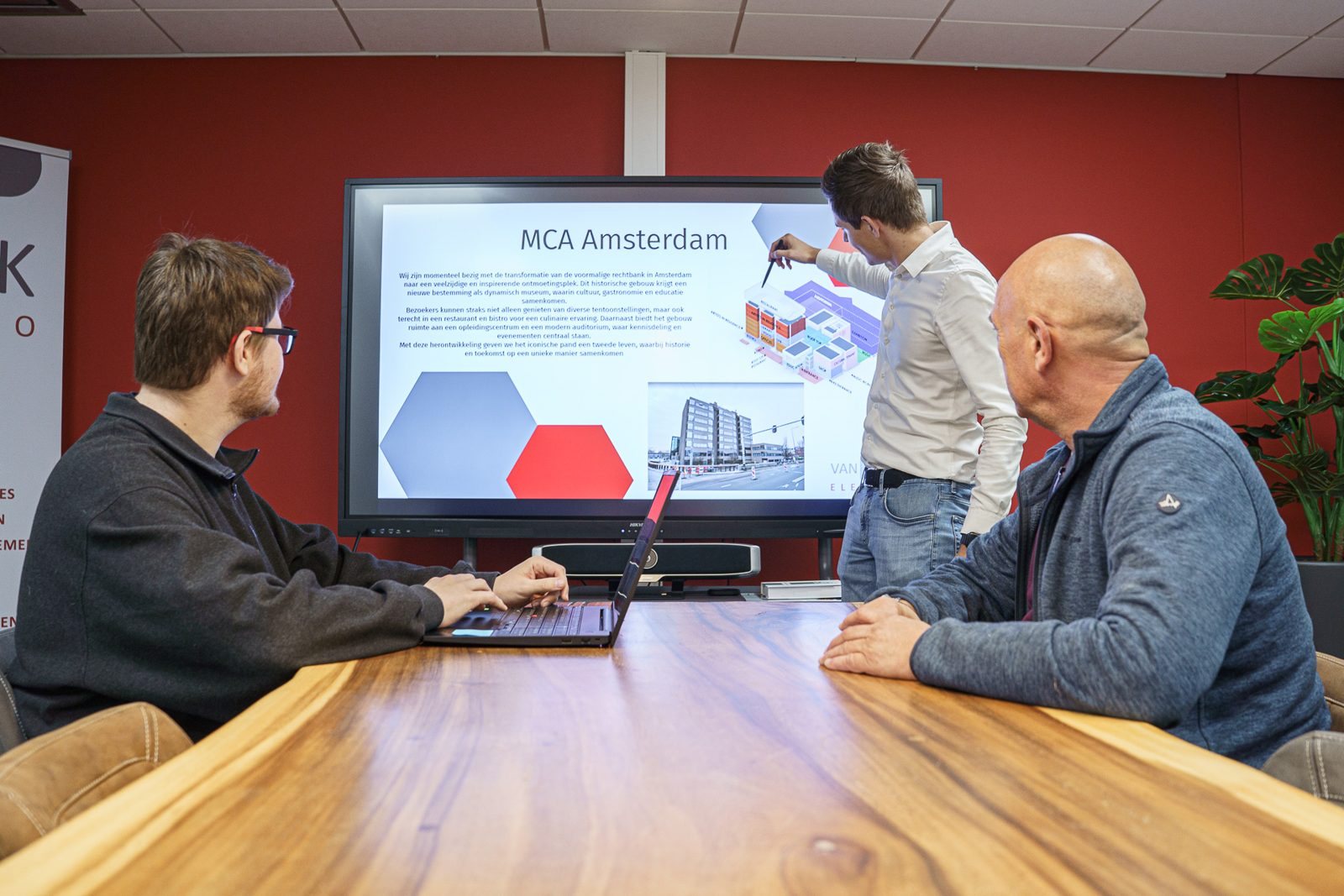 Projectleider Aart licht het project MCA Amsterdam toe aan collega's in de vergaderruimte